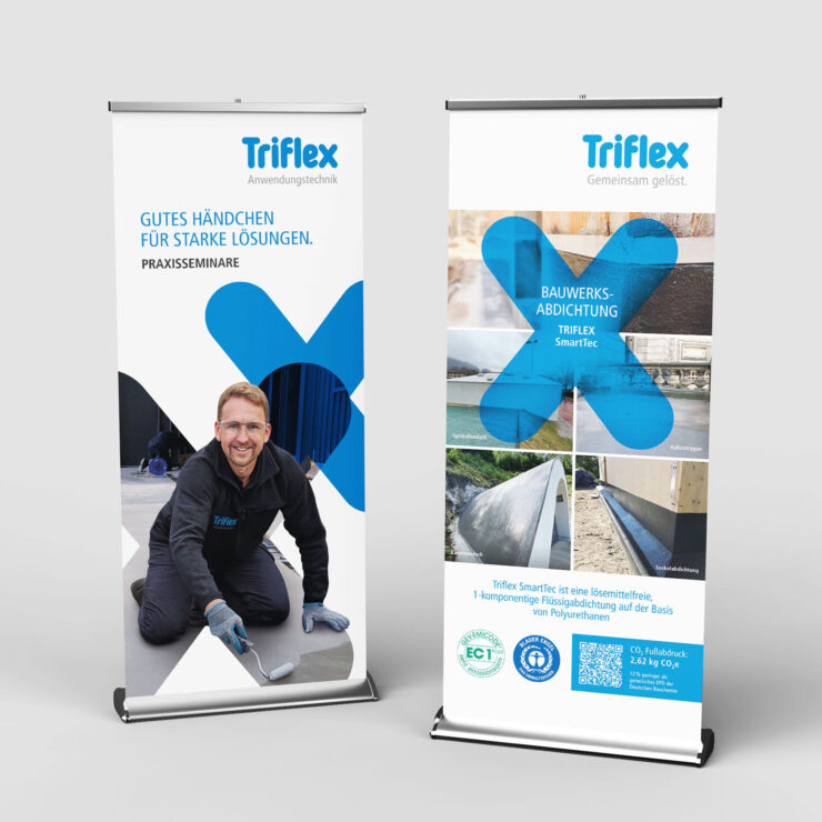 Zwei Roll-Up Banner von Triflex nebeneinander vor einem neutralen Hintergrund