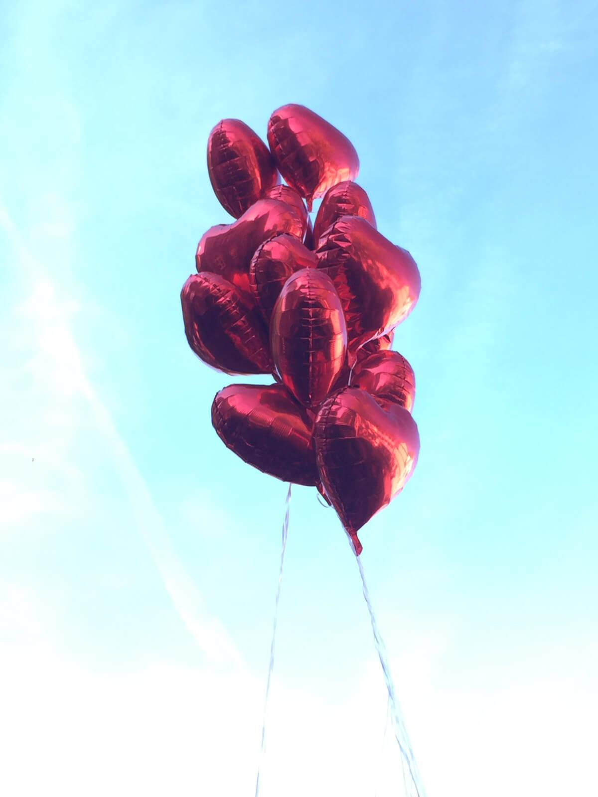 Herzballons vor blauem Himmel
