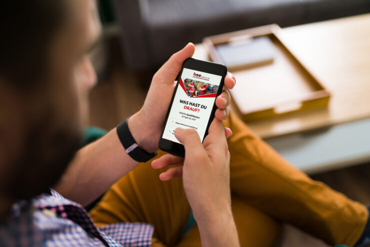Blick über die Schulter eines Mannes, der einen Recruiting-Funnel von hse Steuerungstechnik auf dem Smartphone sieht