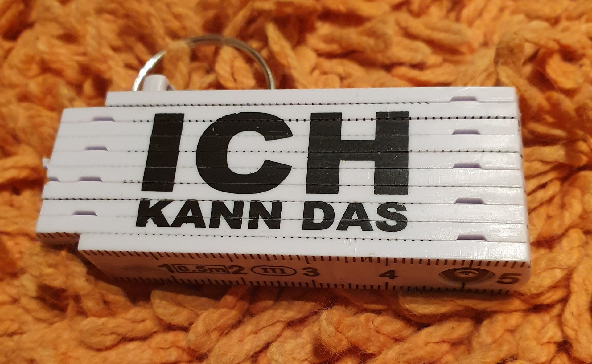 Ein Mini-Zollstock mit der Aufschrift Ich Kann Das