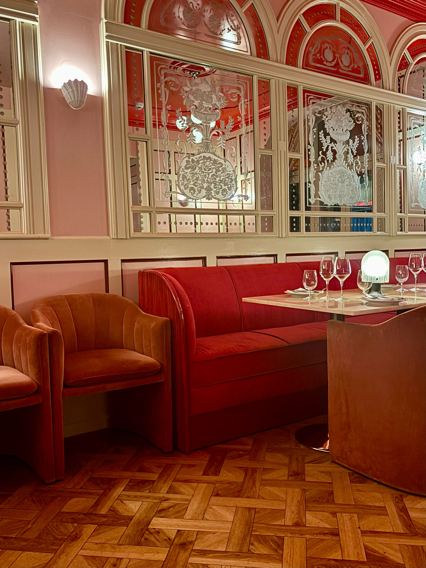 Ein Salon mit roten Sofas und verzierten Spiegeln