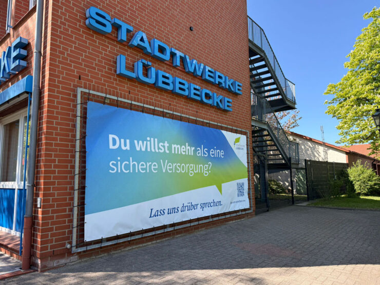 Fassade der Stadtwerke Lübbecke mit großem Banner, auf dem steht: Du willst mehr als eine sichere Versorgung? Lass uns drüber sprechen.